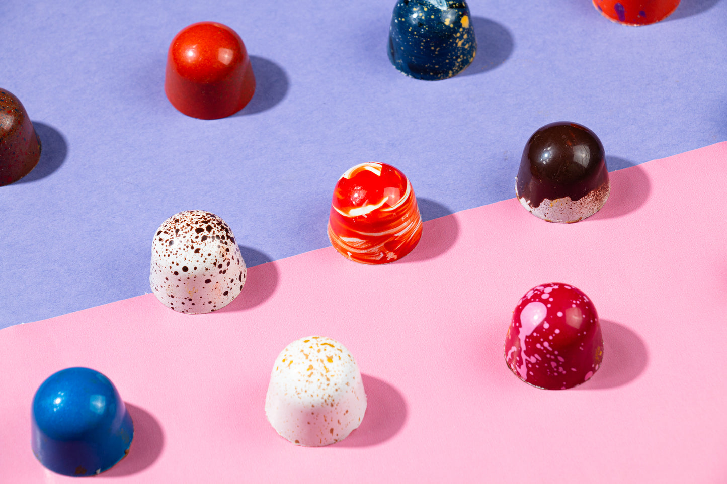 Chocolate bonbons on a pink and purple backdrop